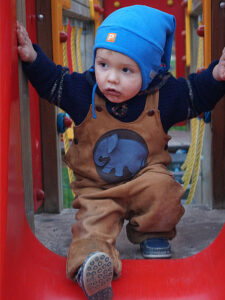 Kinderlederhose Latzlederhose Kind auf Rutsche